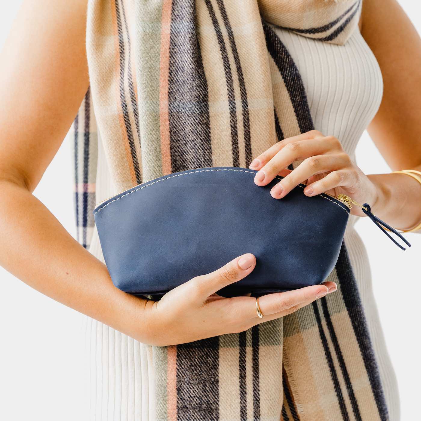 All Color: Deep Water | Spacious leather makeup bag with curved seams and top zipper