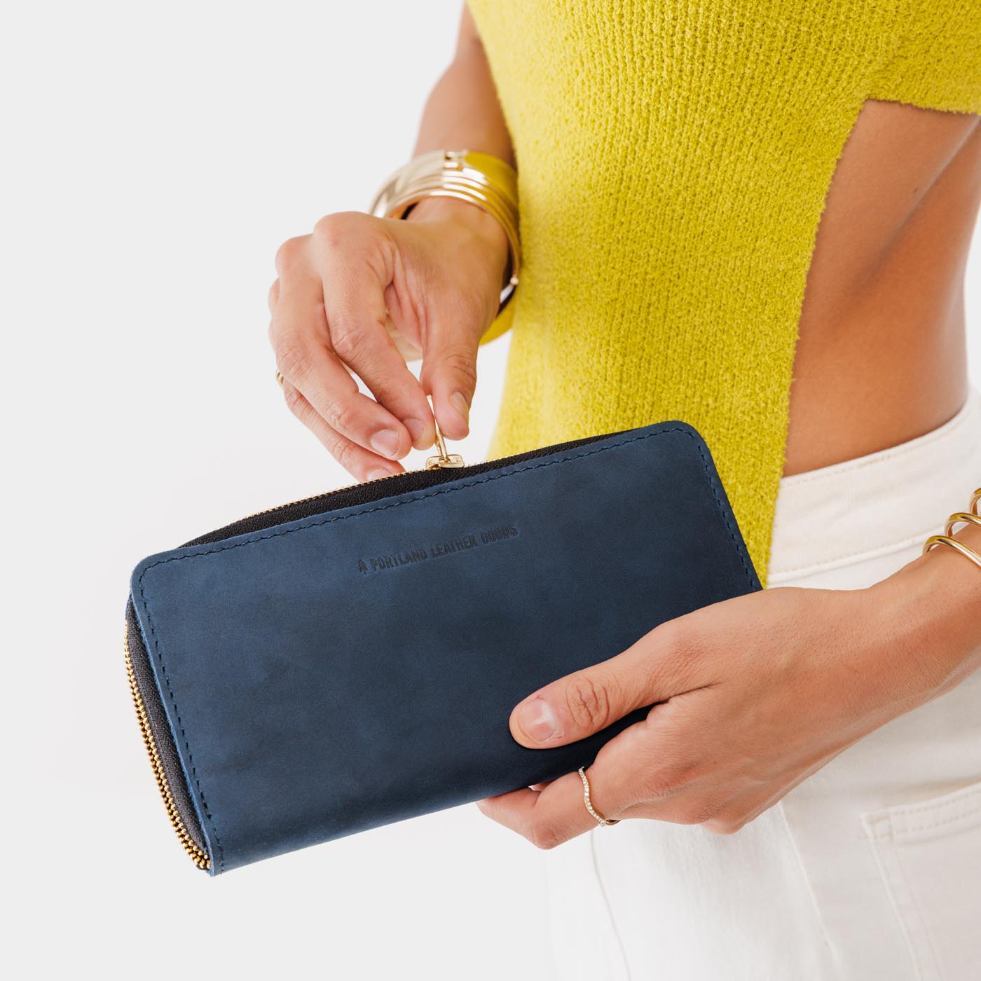 Deep Water | Model holding large accordion leather wallet with zipper closed