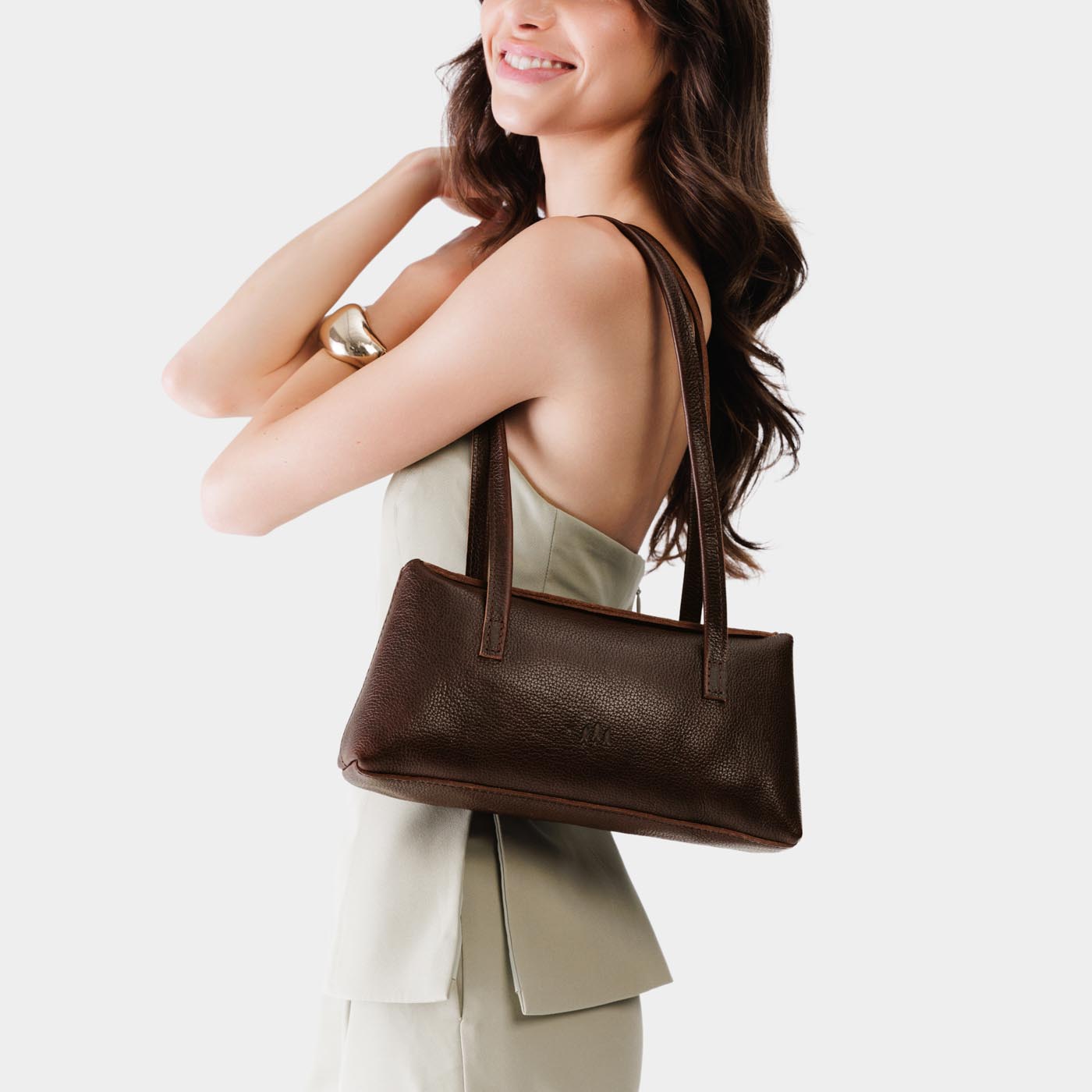Coldbrew | Woman wearing a dark brown leather bowler bag against a white background
