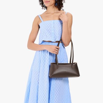 Grizzly | Model wearing light blue skirt with matching top carrying leather bowler bag with magnetic closure