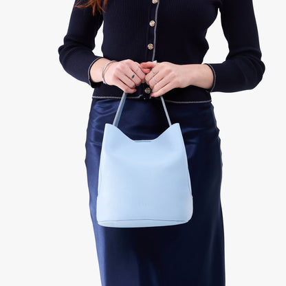 Skyway*Large | Model holding symmetrical bucket bag with handle, latch closure, and removable crossbody strap