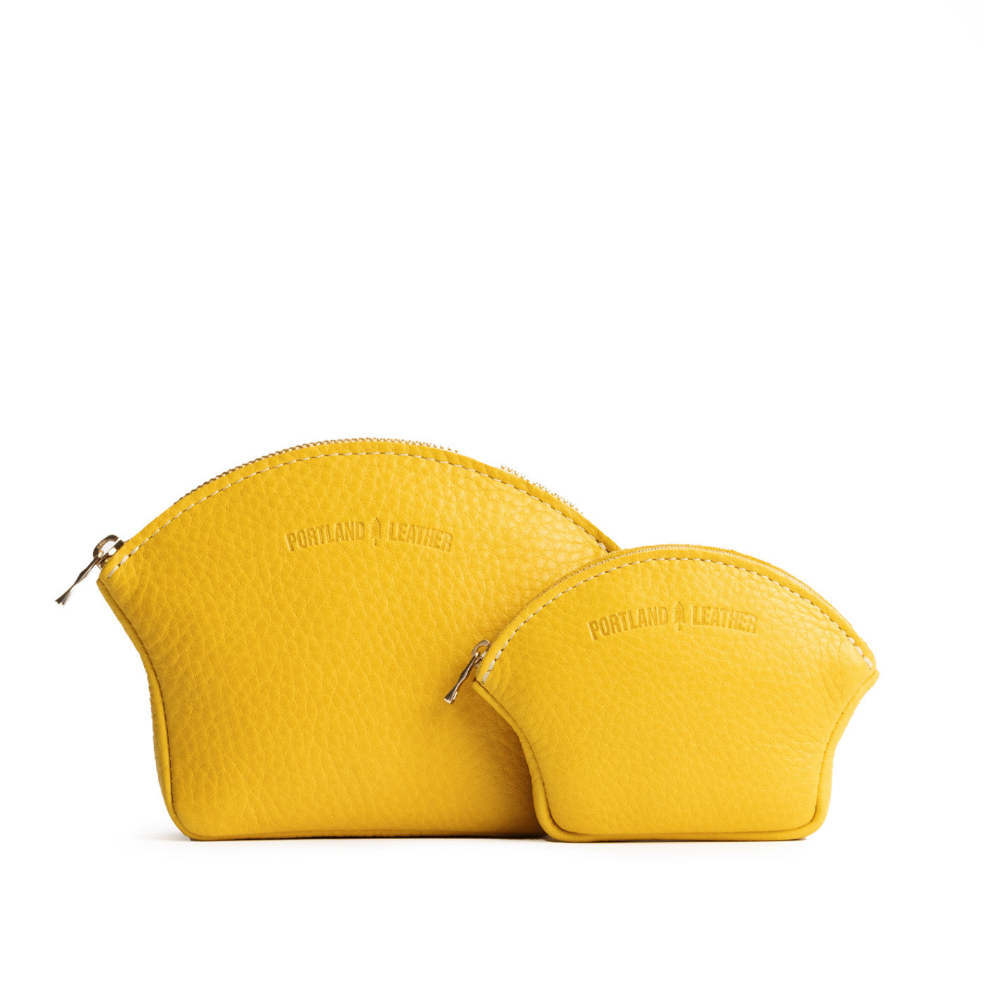 Naples | Comparison shot of small and large seashell shaped leather makeup bags with curved top zipper and flat bottom