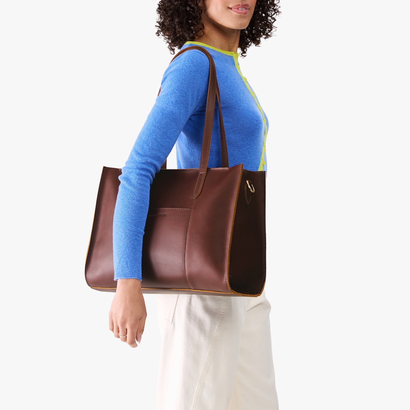 Cognac*Oversized East/West | Model holding structured wide tote bag with overlapping panels and crossbody strap