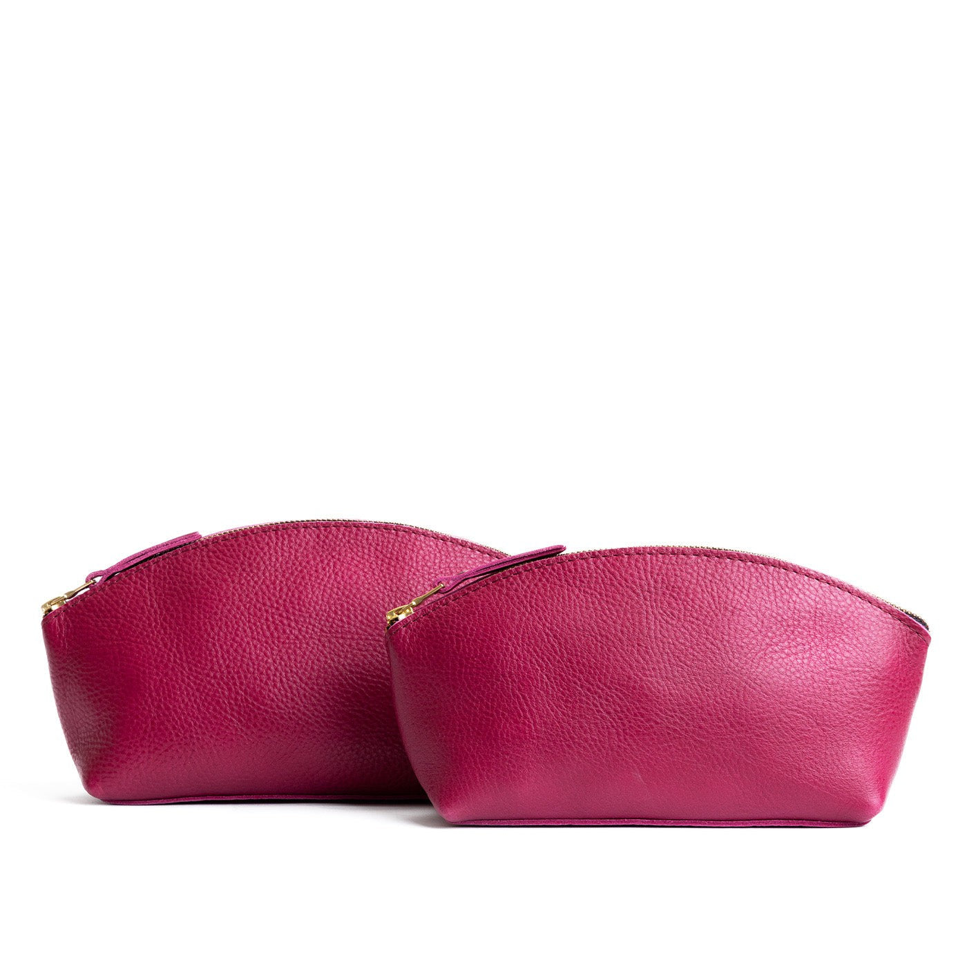 Cosmo | Size comparison shot of two spacious leather makeup bags with curved seams and top zipper