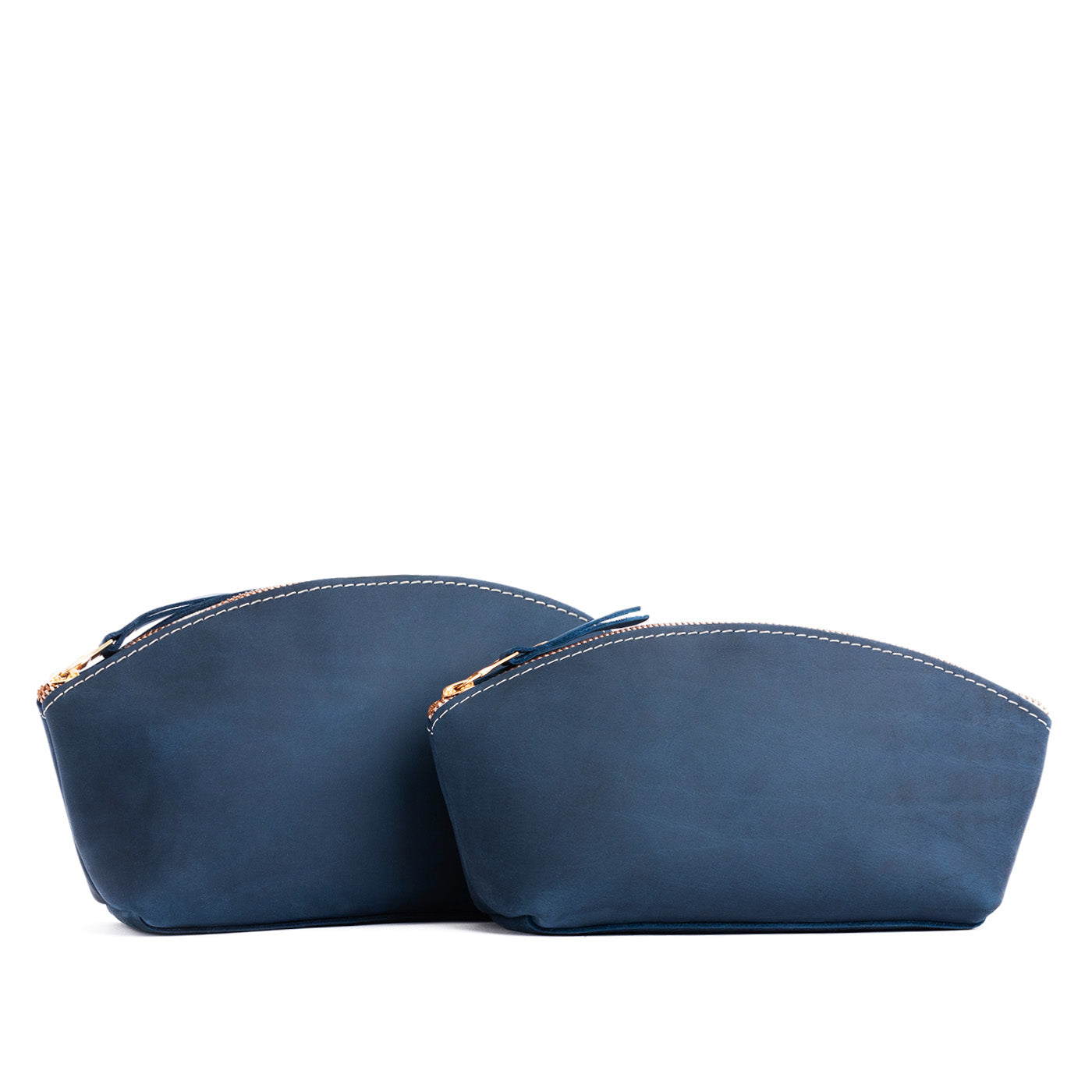 Deep Water | Size comparison shot of two spacious leather makeup bags with curved seams and top zipper