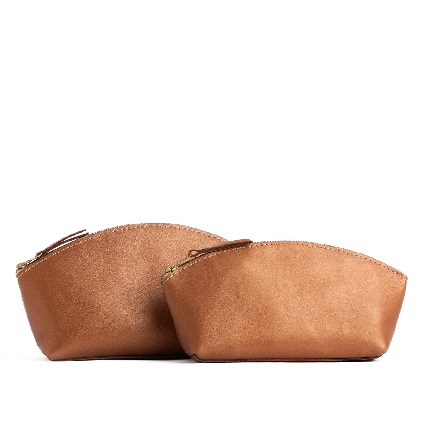 Hava | Size comparison shot of two spacious leather makeup bags with curved seams and top zipper