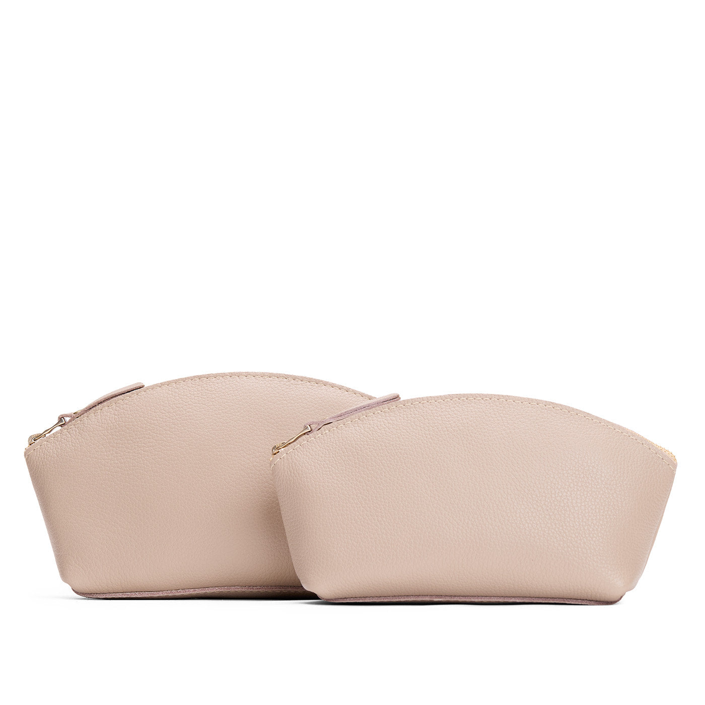 Oatmilk | Size comparison shot of two spacious leather makeup bags with curved seams and top zipper