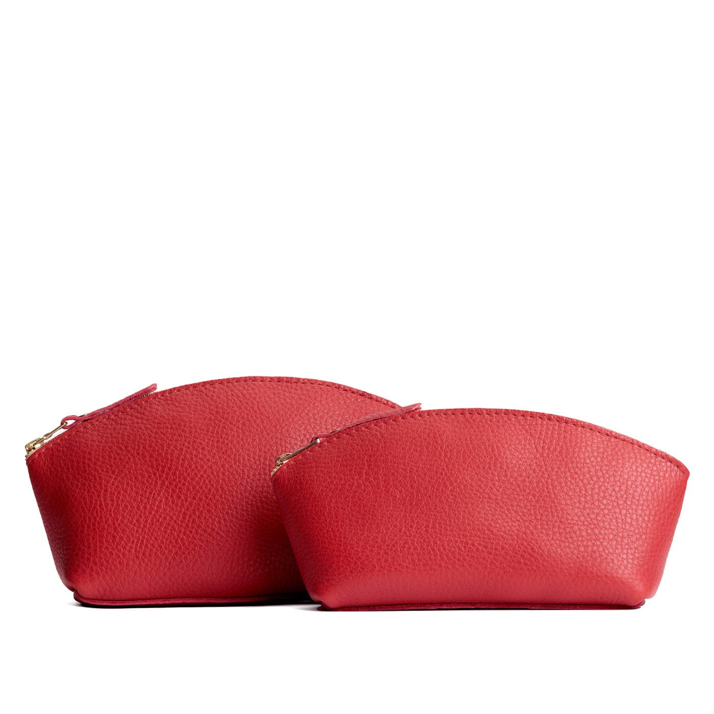 Sugar | Size comparison shot of two spacious leather makeup bags with curved seams and top zipper