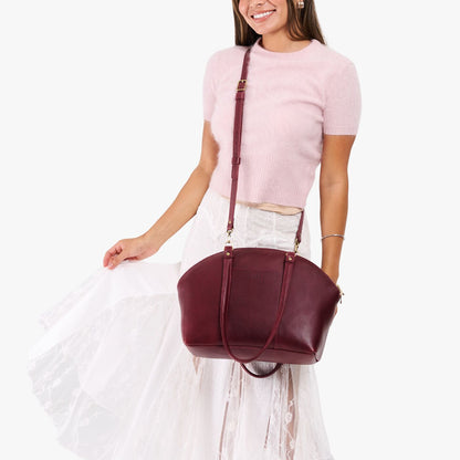 Cabernet*Large | Model holding a half circle crossbody bag with handles and removable crossbody strap