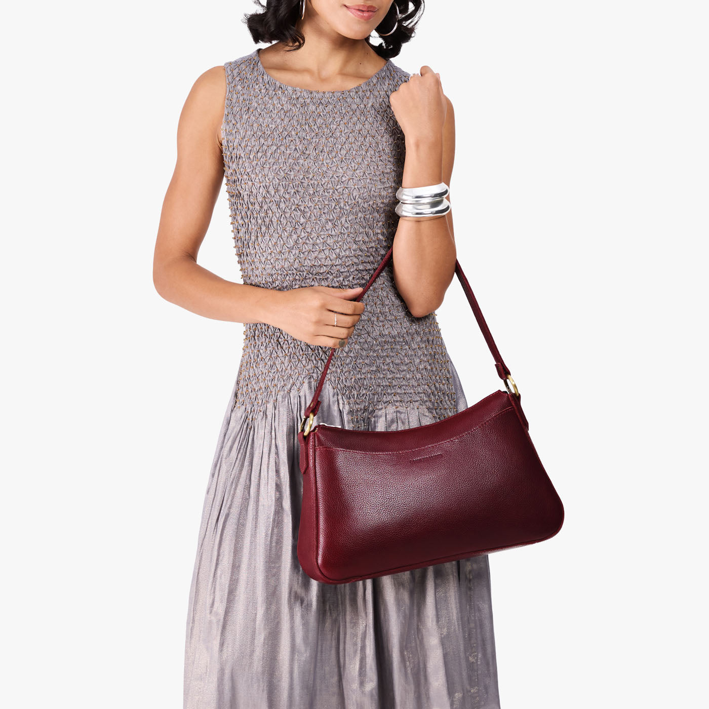 Cabernet*Large | Model holding a bean shaped shoulder bag with a zipper closure