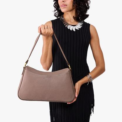 Sparrow*Large | Model holding a bean shaped shoulder bag with a zipper closure