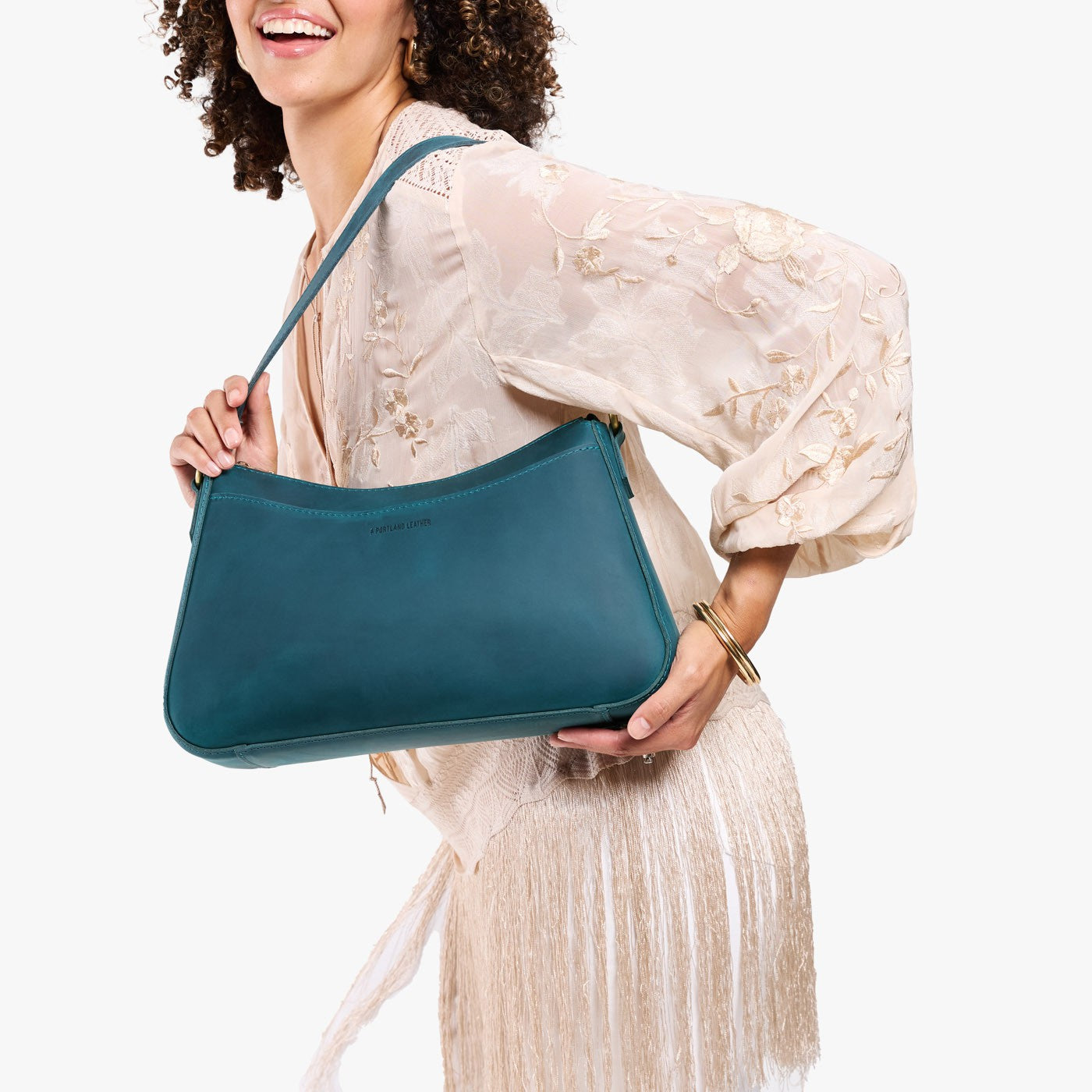Westward Blue*Large | Model holding a bean shaped shoulder bag with a zipper closure