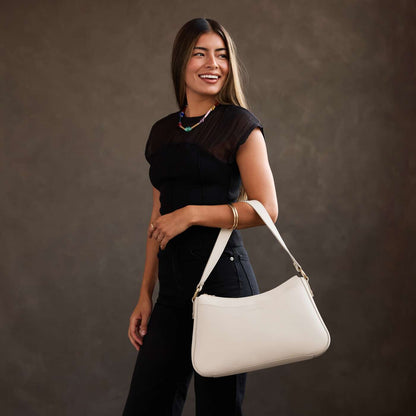Bone*Large | Model holding a bean shaped shoulder bag with a zipper closure