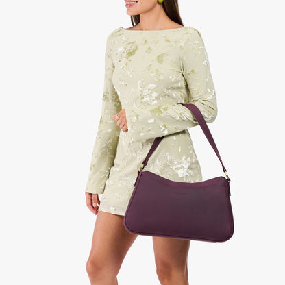 Larkspur*Large | Model holding a bean shaped shoulder bag with a zipper closure