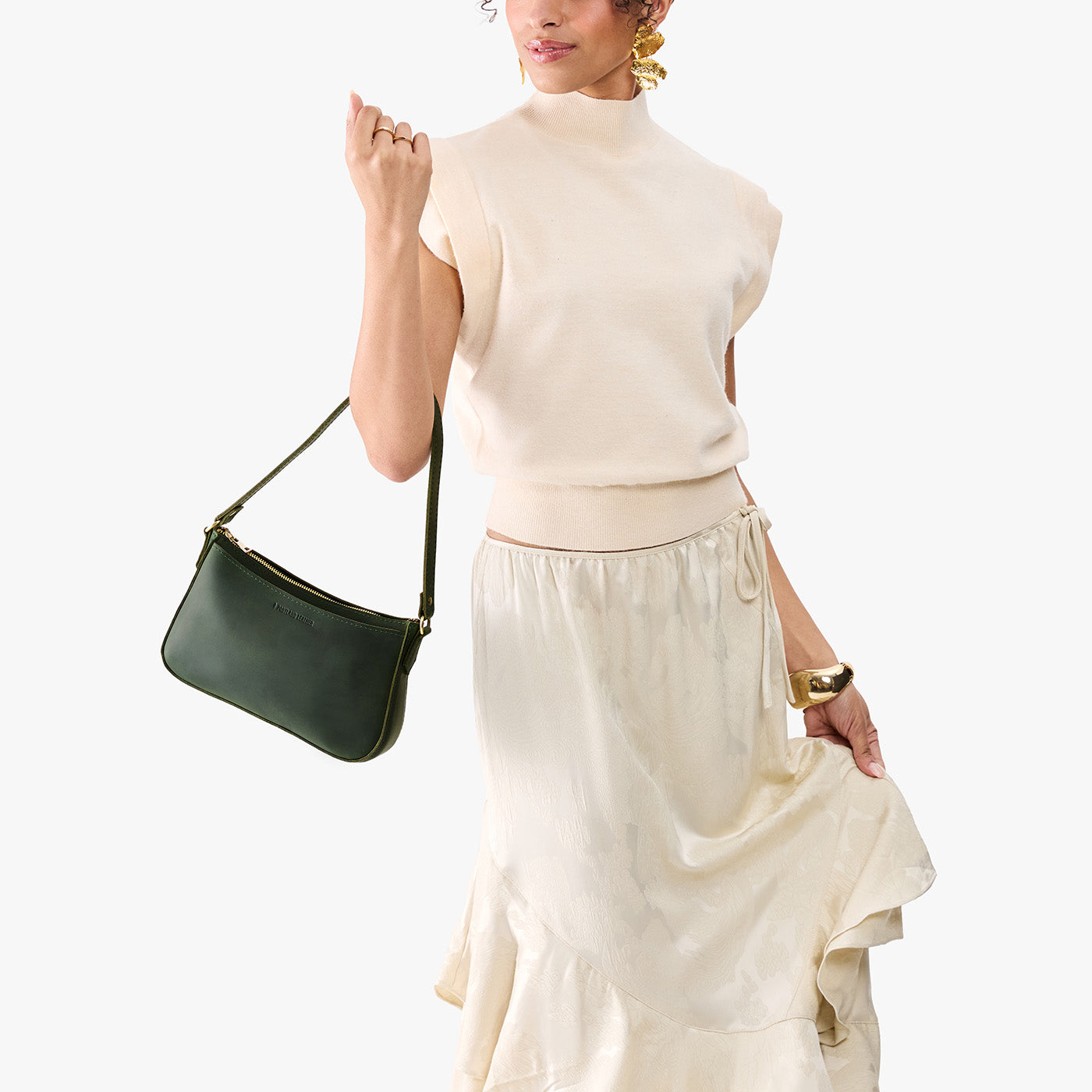 Evergreen*Small | Model carrying petite bean shaped shoulder bag with a zipper closure