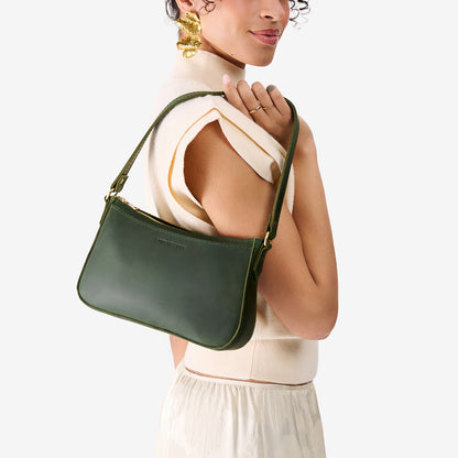 Evergreen*Small | Model carrying petite bean shaped shoulder bag with a zipper closure