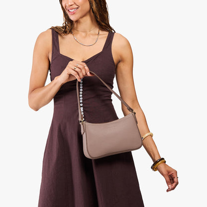 Sparrow*Small | Model carrying petite bean shaped shoulder bag with a zipper closure