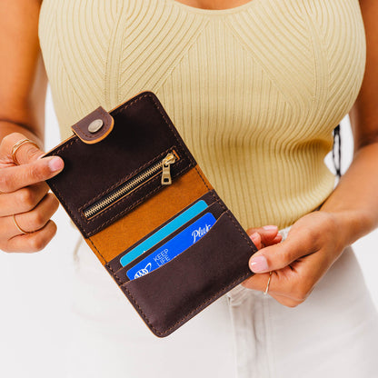 Grizzly | Model holding small leather bifold wallet with snap open