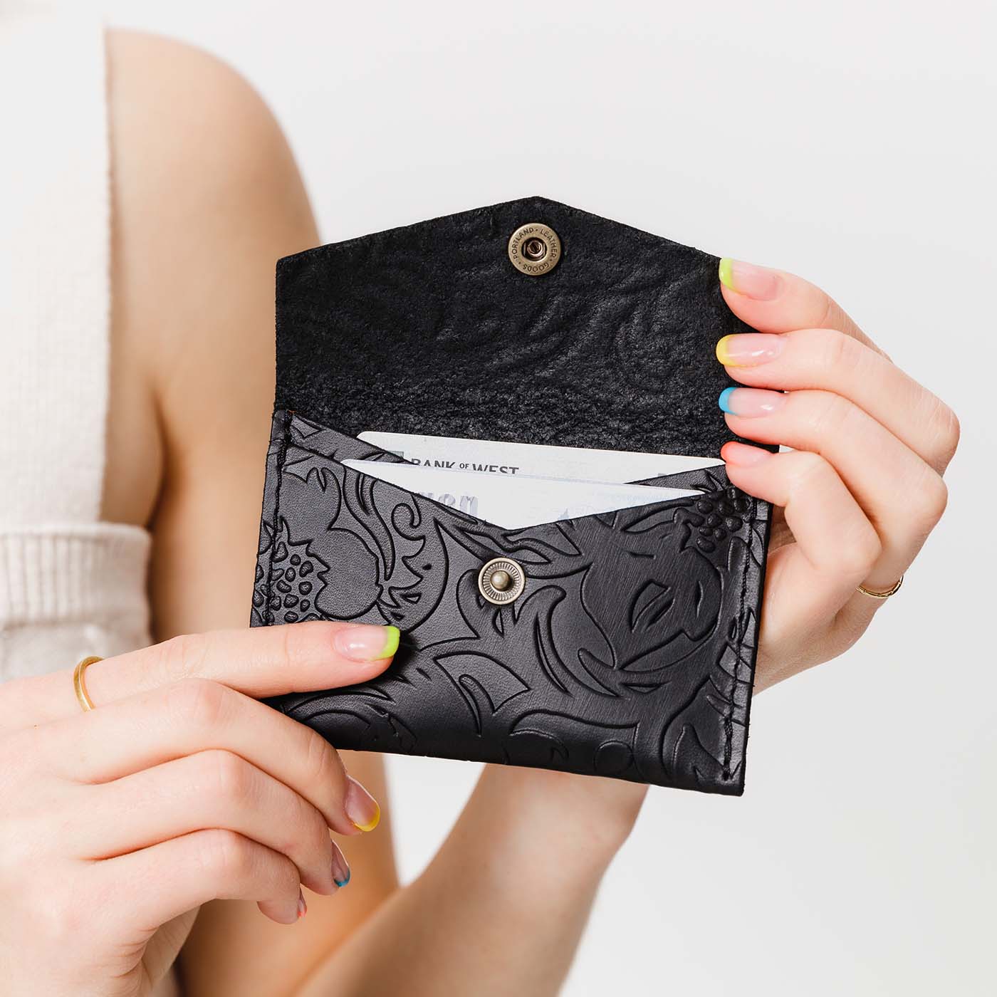 Dahlia | Model holding small leather envelope wallet with snap closure open
