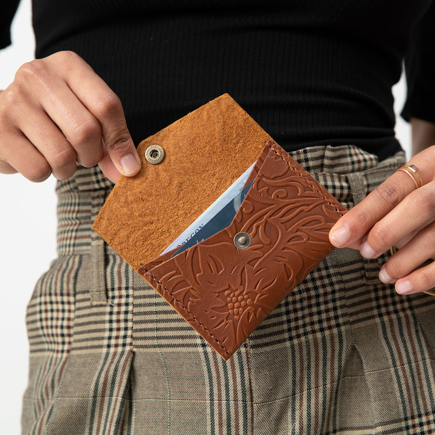 Meadow | Model holding small leather envelope wallet with snap closure open