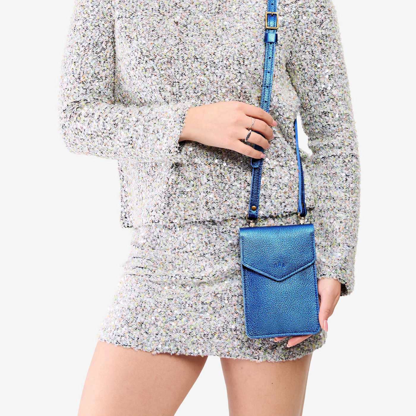Comet Blue | Model wearing slim, phone-shaped crossbody purse with magnetic closure