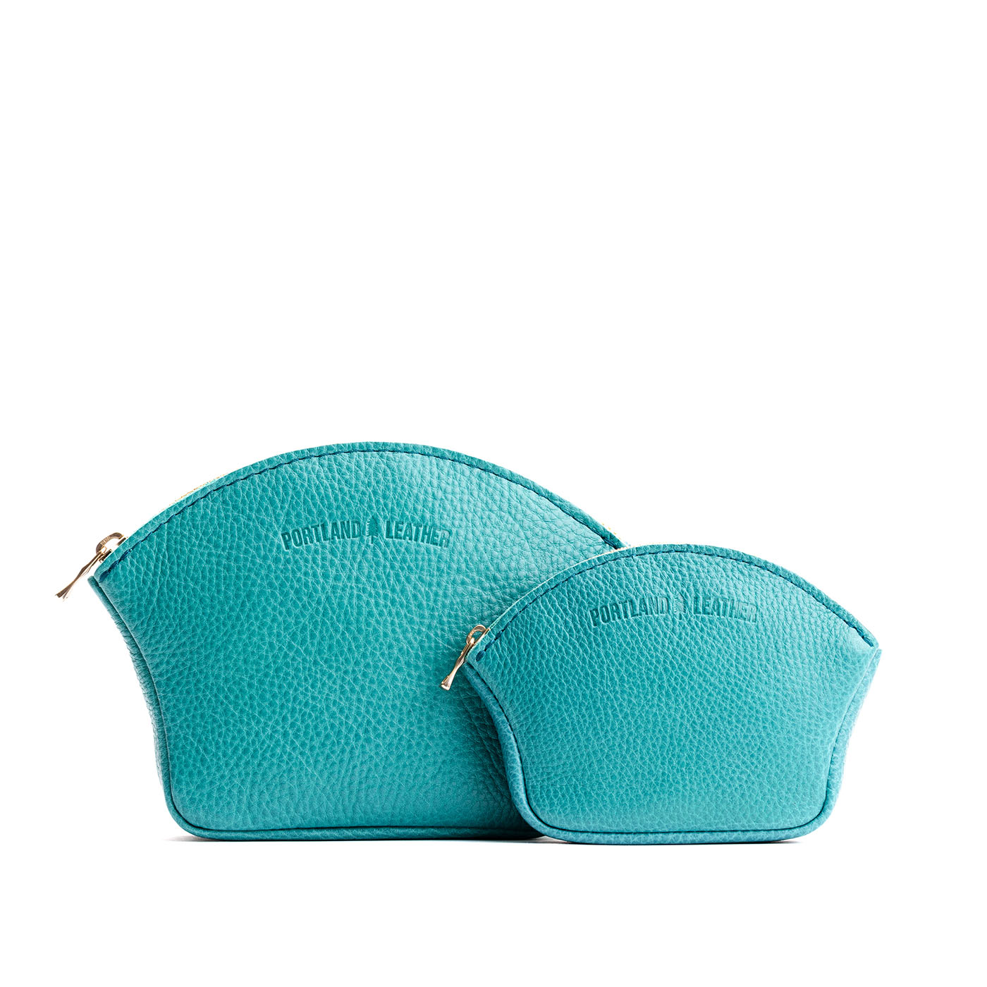 Seafoam | Comparison shot of small and large seashell shaped leather makeup bags with curved top zipper and flat bottom