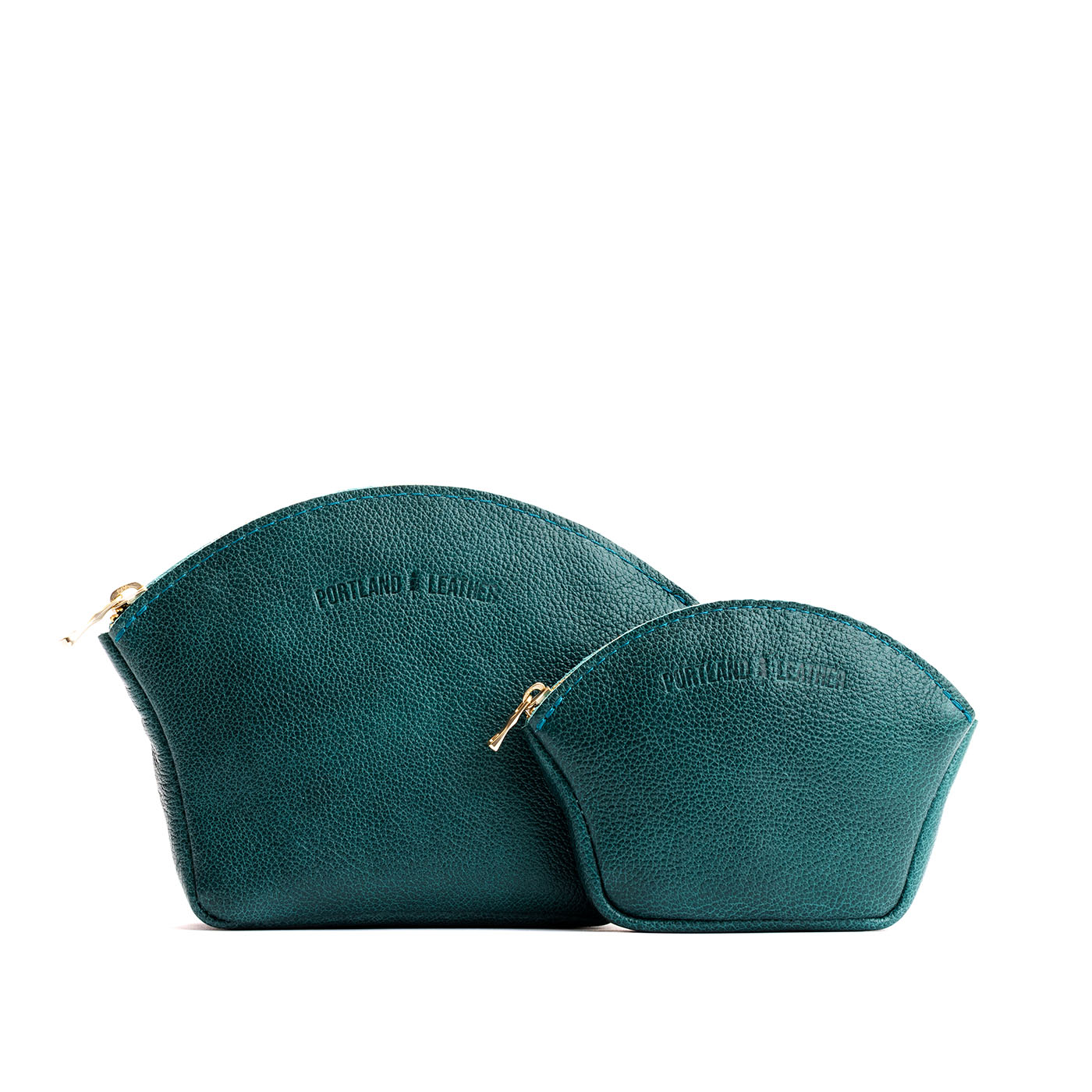 Sea Glass | Comparison shot of small and large seashell shaped leather makeup bags with curved top zipper and flat bottom
