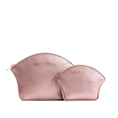 Supernova | Comparison shot of small and large seashell shaped leather makeup bags with curved top zipper and flat bottom