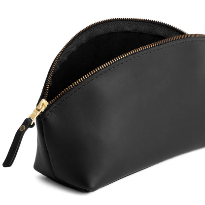 Black | Spacious leather makeup bag with curved seams and top zipper open
