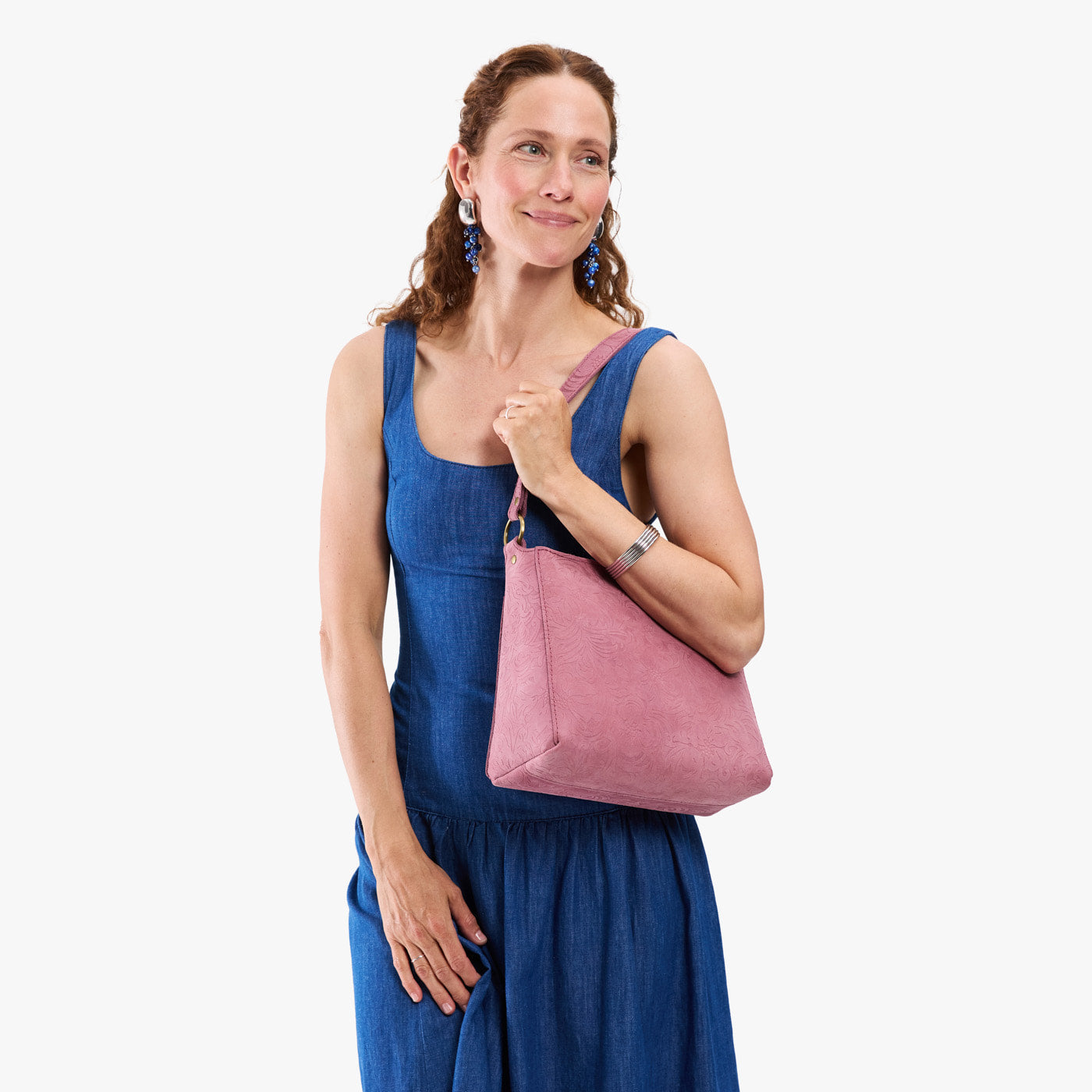 Hollyhock | Model holding a triangular shoulder bag with antiqued brass finished