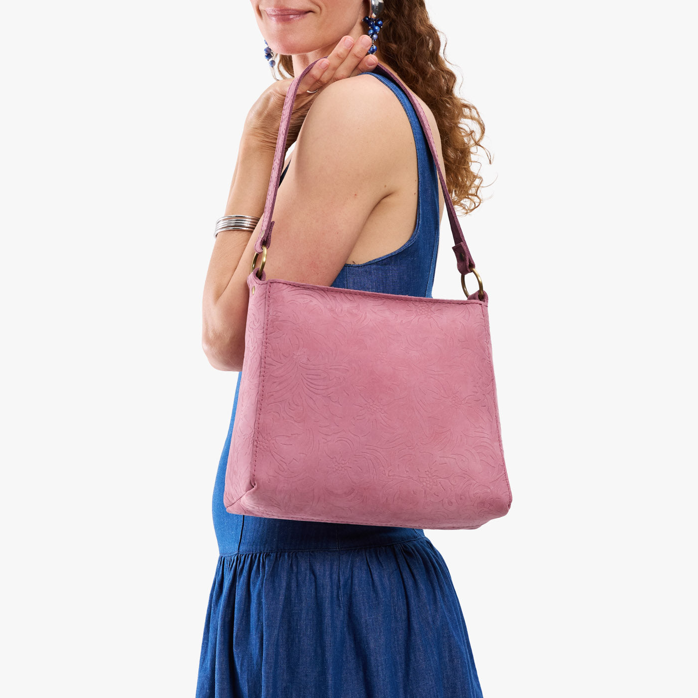 Hollyhock | Model holding a triangular shoulder bag with antiqued brass finished