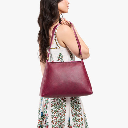 Orchid*Large | Model carrying large triangular shoulder bag with antiqued brass finished hardware