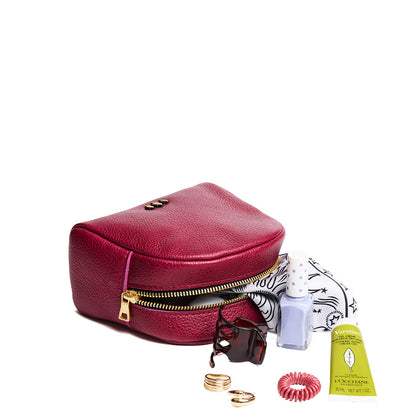 ANY | Curved top leather pouch with zipper opening, flat base, and three metal tree emblems in front